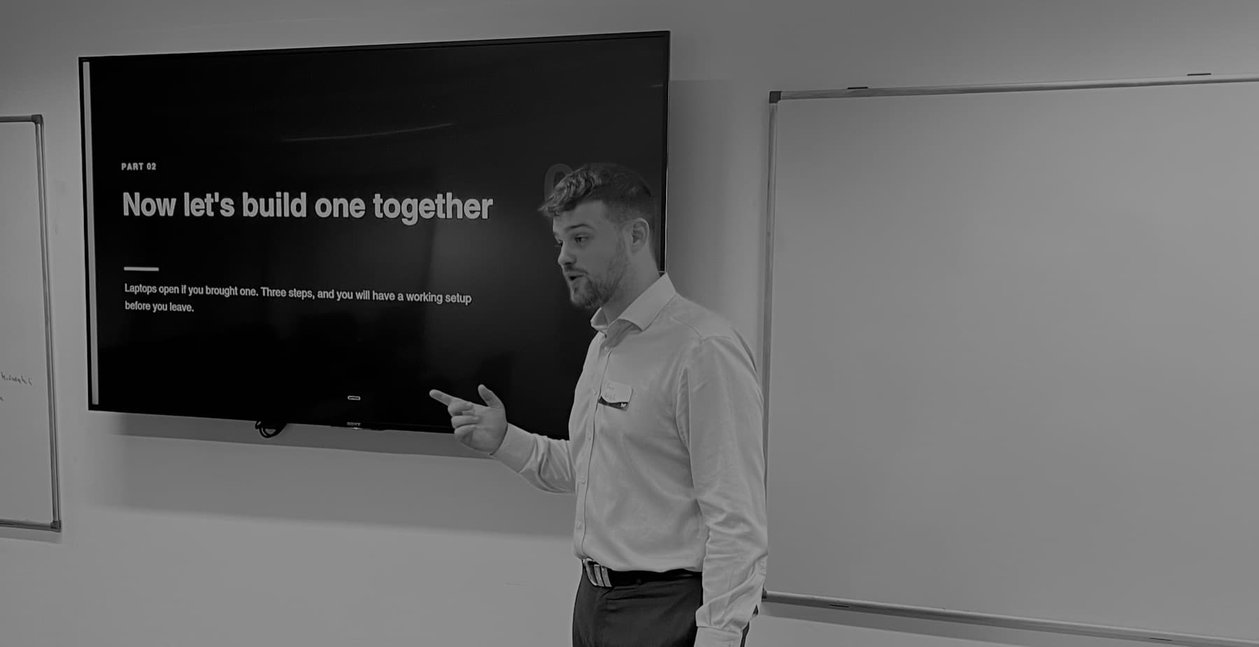 Will May in front of a screen reading Now let's build one together, at an AI Edge session in Reading